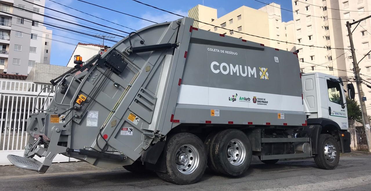 Caminhão da coleta domiciliar comum passando por uma rua do Jardim Novo Mundo